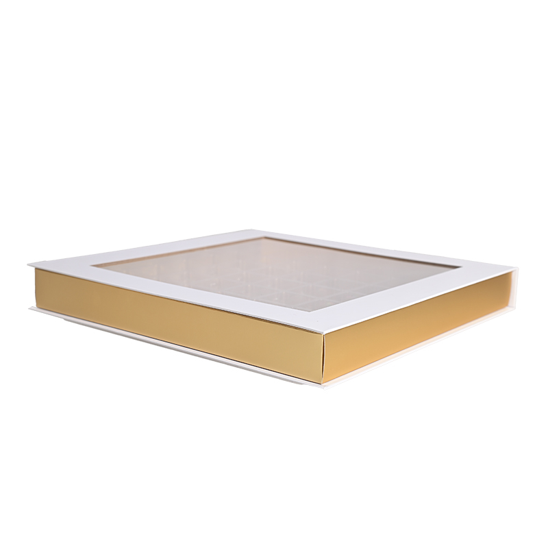 Geschlossene luxuriöse weiße und goldene Schokoladen box mit einem großen transparenten, durchsichtigen Schaufenster oben.